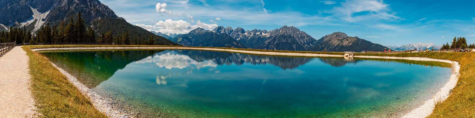 High resolution stitched alpine summer panorama with reflections in a lake at Serles cable car station, Mieders, Stubaital valley, Innsbruck, Austria