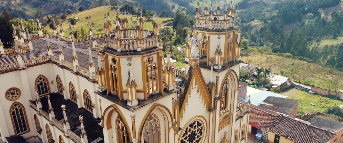 A cathedral with intricate architecture and a scenic valley in the background.