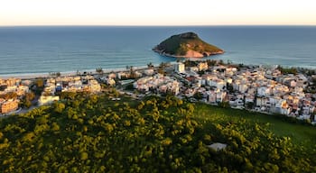 aerial landscape photo of Recreio dos Bandeirantes beach during sunset, with views of Chico Mendes park and the Pontal Stone bathed by orange sunlight