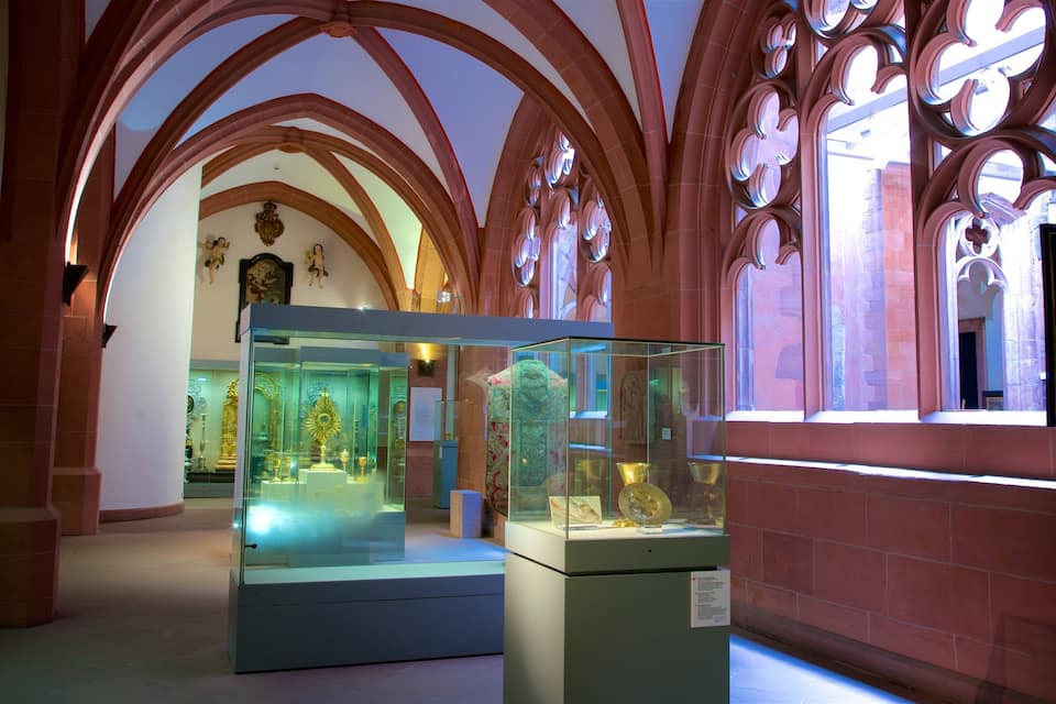 Interior de museu amb sostres arquejats i vitrines de vidre que contenen artefactes.