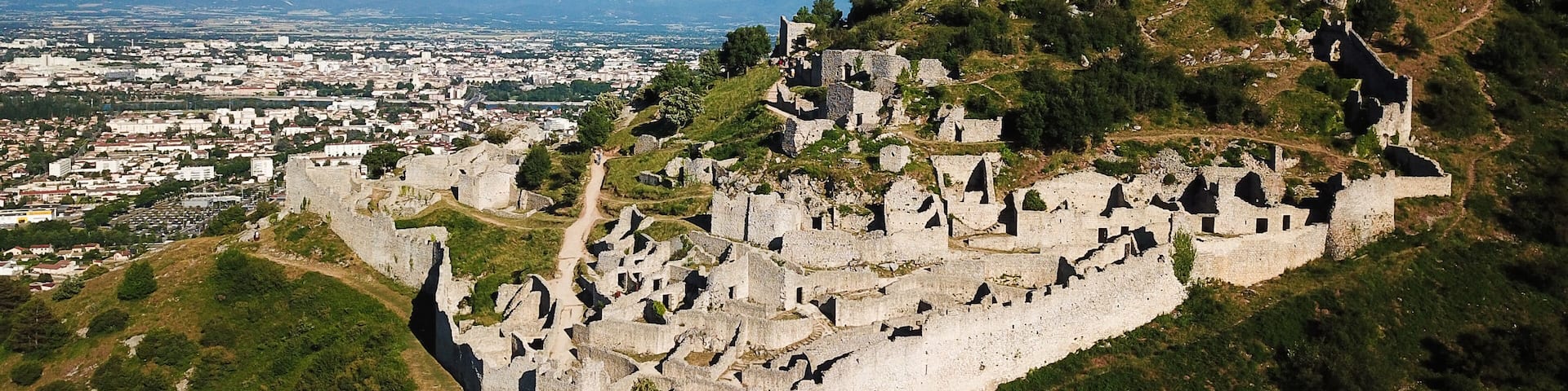 Aerial view of the medieval ruins of Chateau de Crussol on a limestone ridge overlooking the Rhone valley in Saint-Peray, Auvergne-Rhone-Alpes, France.