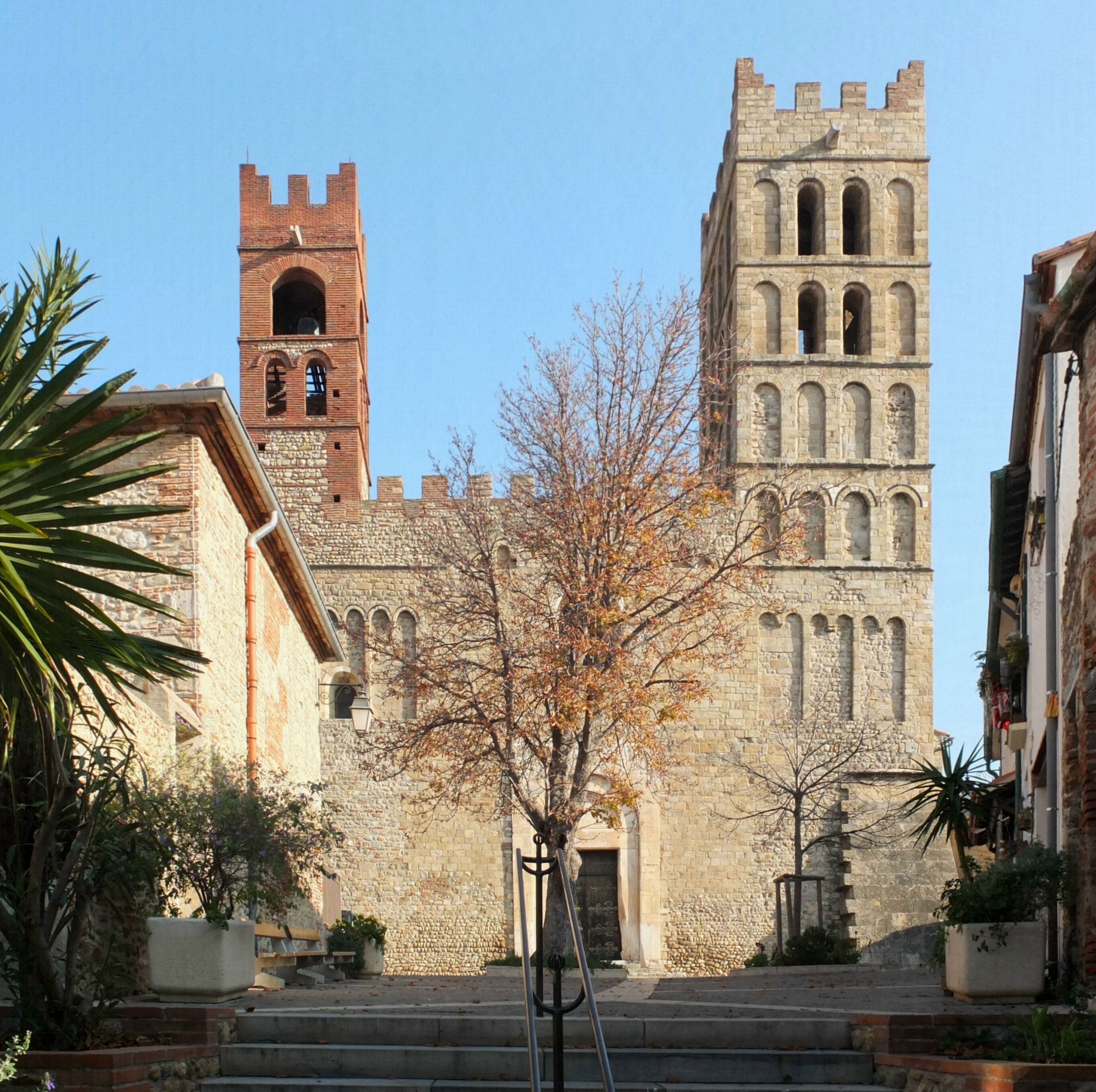 A historic stone building with a bell tower and arched windows.
