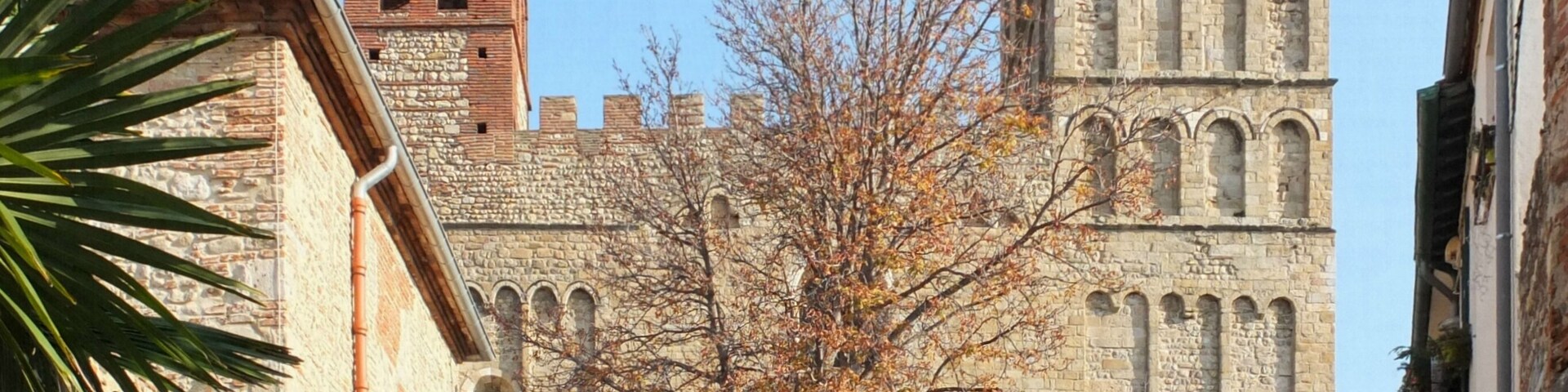 A historic stone building with a bell tower and arched windows.
