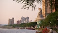 A river with boats, a bridge, and a statue of a horse.