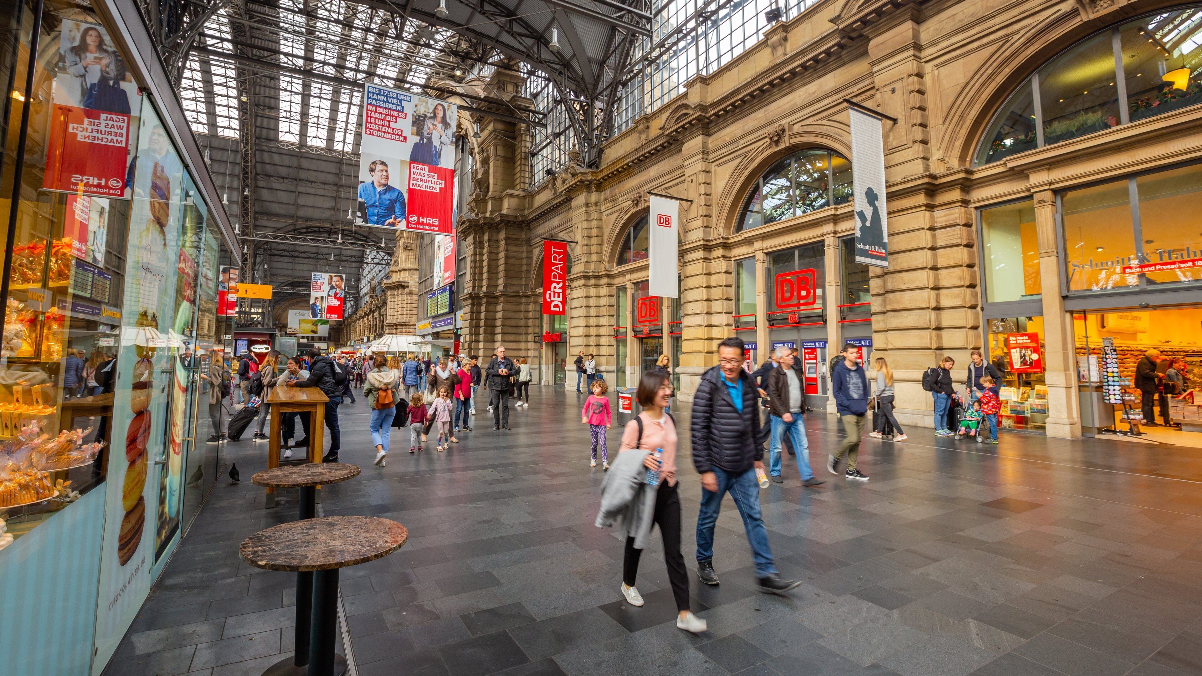 A busy indoor market with people walking and shops on either side.