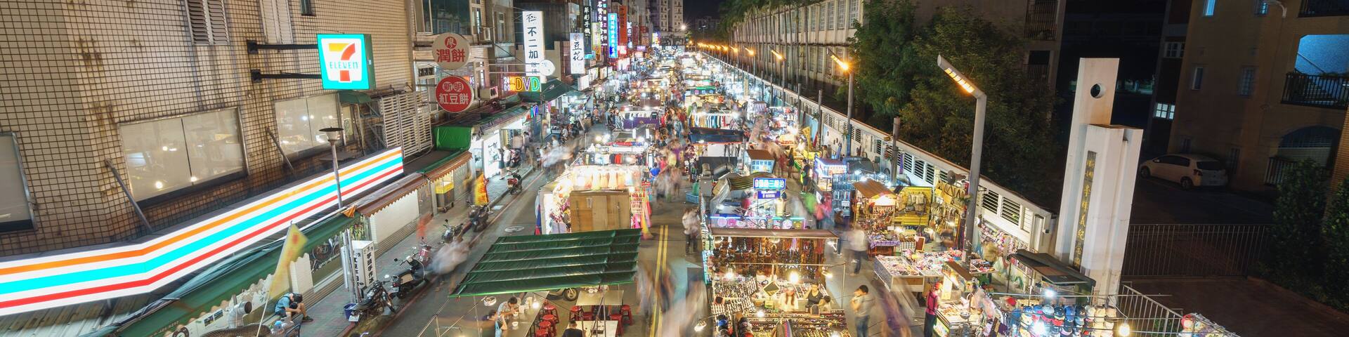 Un marché nocturne animé, avec de nombreux étals et vendeurs.