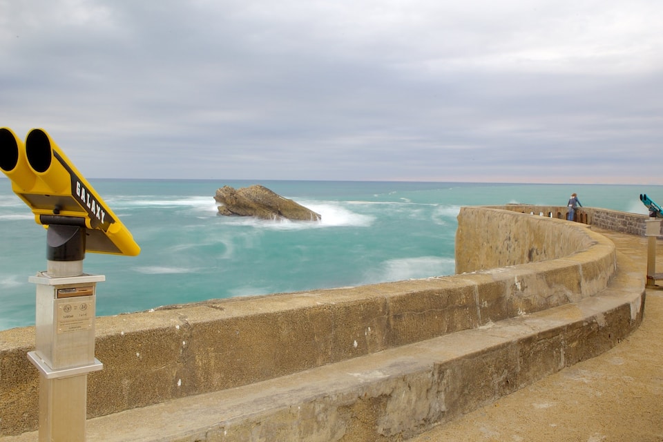 A telescope labeled "GALAXY" overlooking the ocean with waves crashing against a rocky outcrop.
