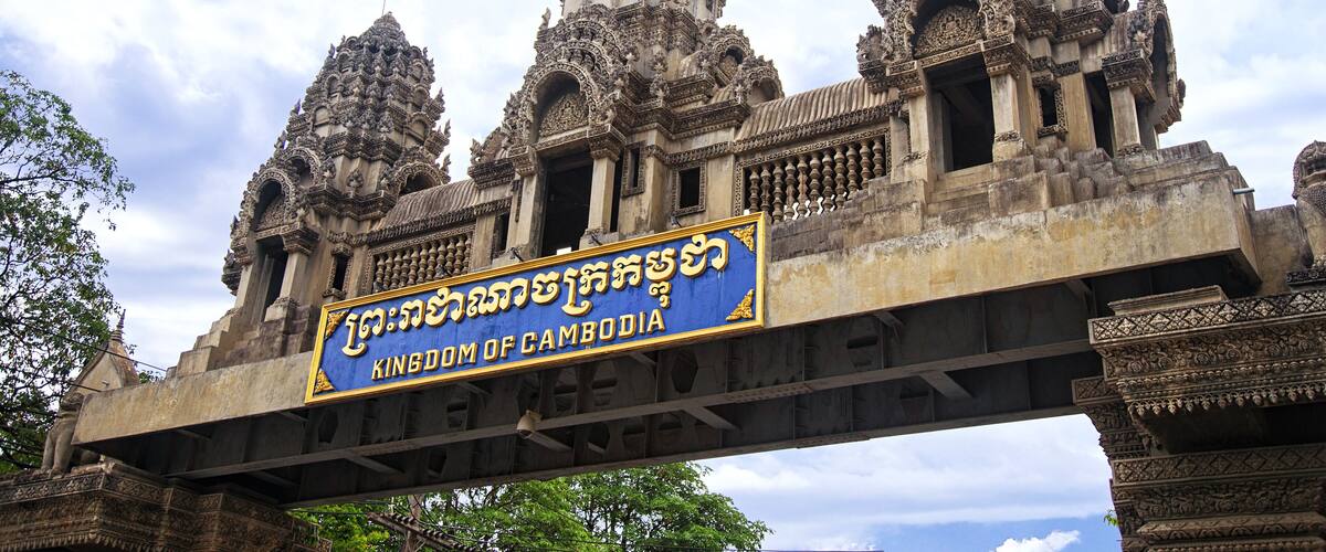 A temple with intricate carvings and a sign that reads "Kingdom of Cambodia".