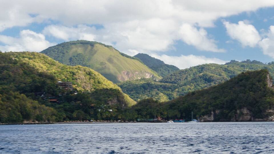 A coastal landscape with a prominent mountain and a body of water.