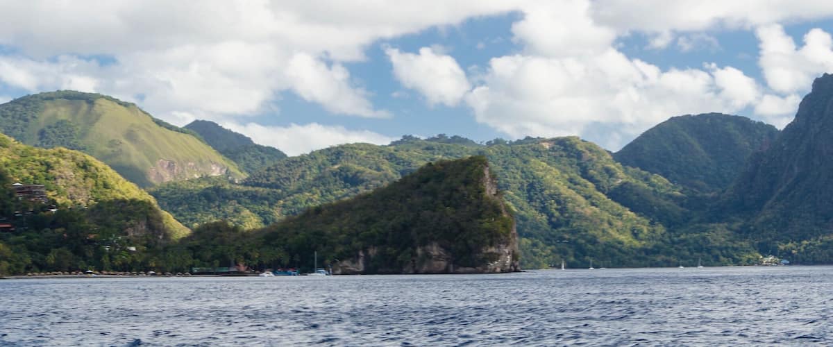 A coastal landscape with a prominent mountain and a body of water.
