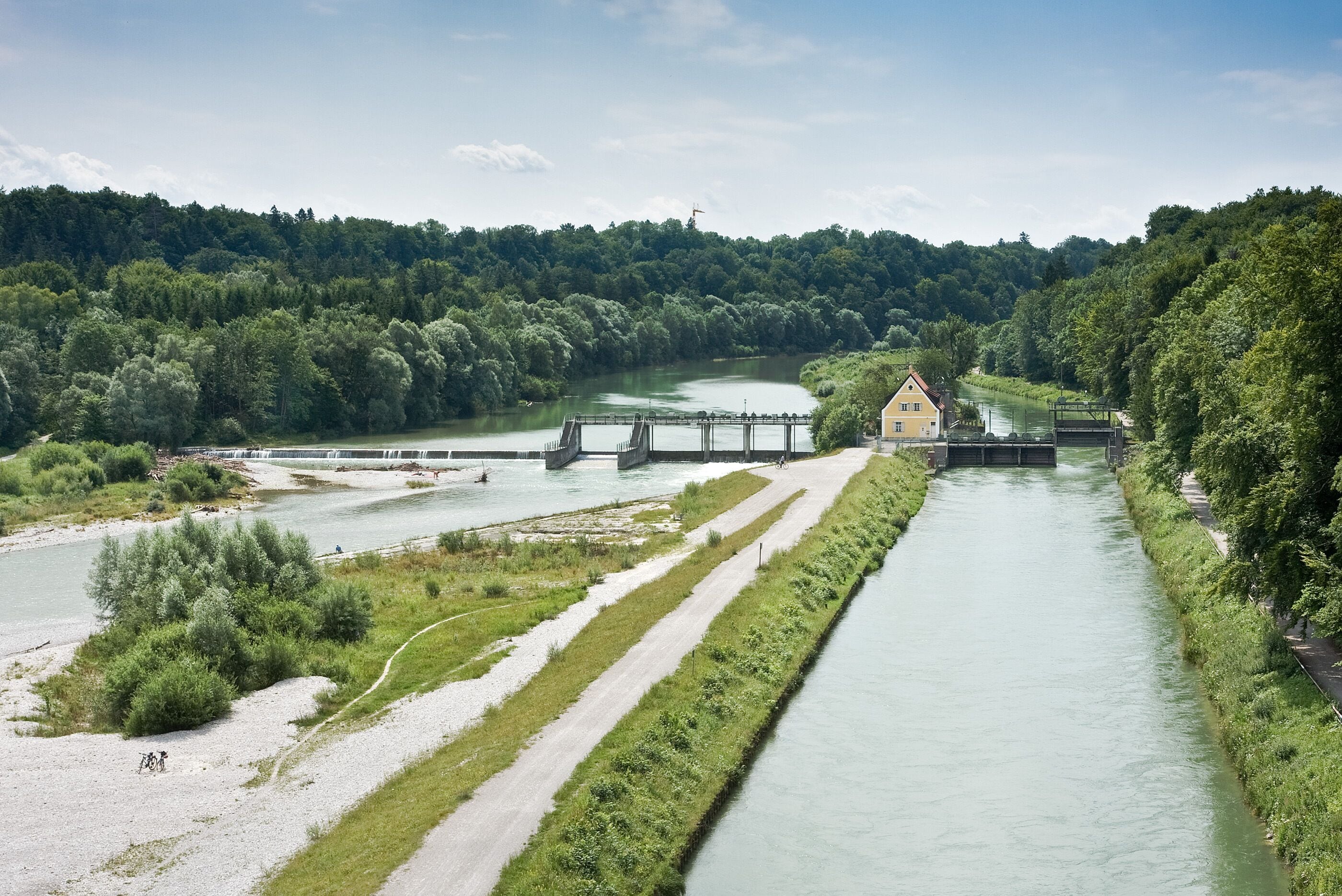 A river with a dam, a bridge, and a house near the water.