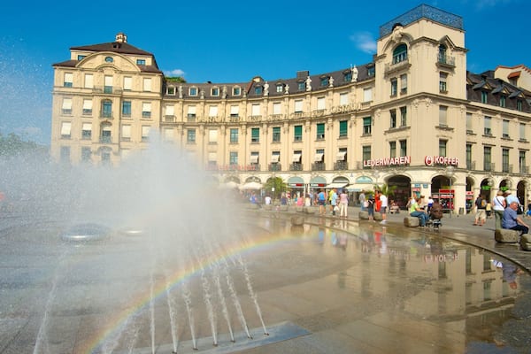 Ein historisches Gebäude mit einem Brunnen davor.