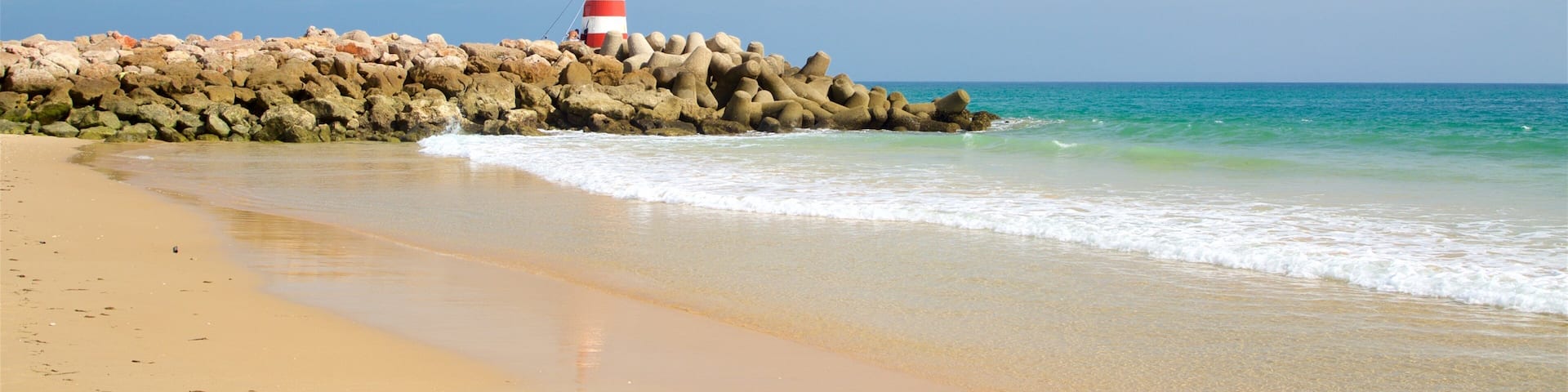 Playa Ilha de Tavira que incluye una playa, vistas generales de la costa y costa escarpada