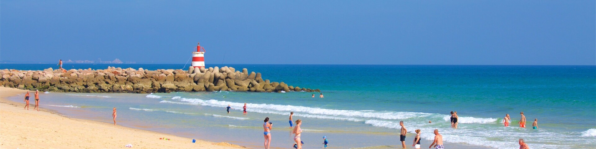 Ilha de Tavira Beach featuring rugged coastline, swimming and general coastal views