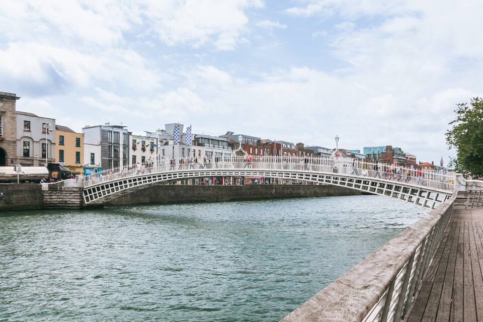 A white bridge over a river with buildings on either side.