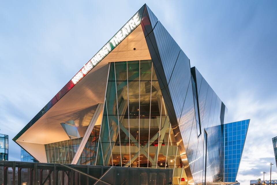 A modern architectural building with a glass facade and a unique triangular design.