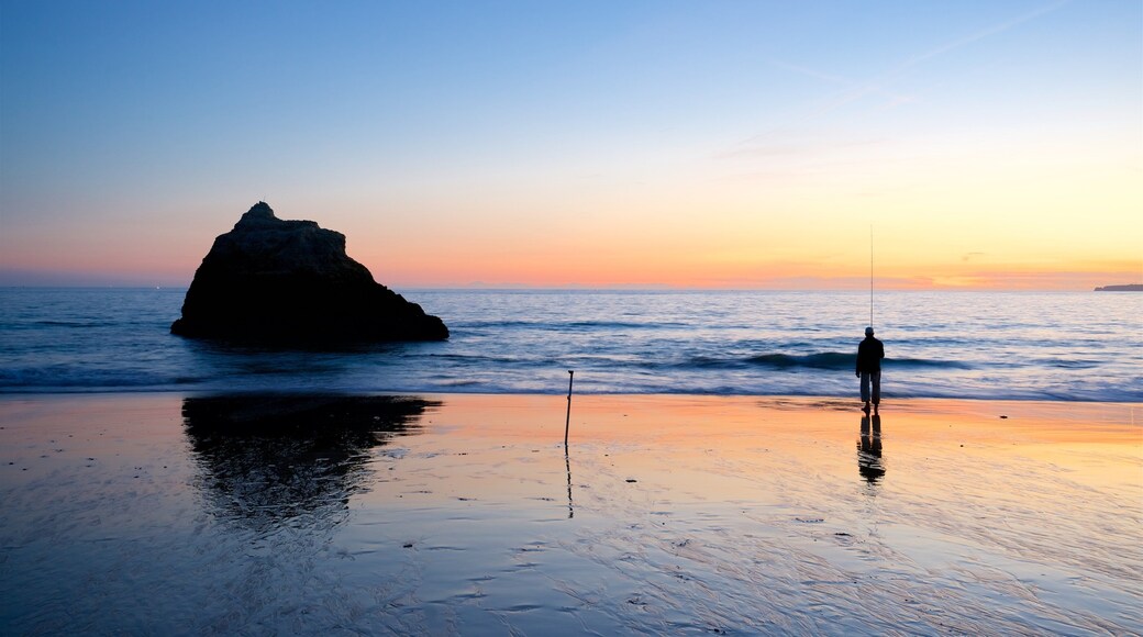 Playa Três Irmãos ofreciendo una playa de arena, una puesta de sol y vistas generales de la costa