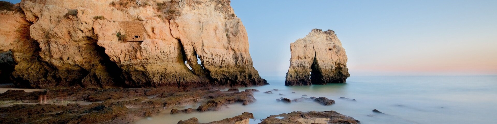 Praia Três Irmãos que inclui uma praia de areia, litoral rochoso e um pôr do sol