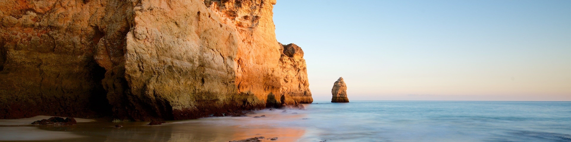Playa Três Irmãos mostrando vistas de una costa, un atardecer y litoral rocoso