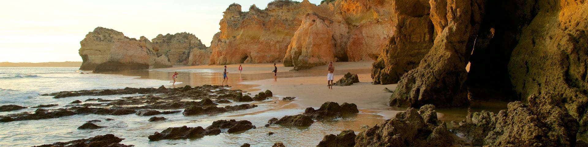 Tres Irmaos Beach featuring rugged coastline, a sandy beach and a sunset
