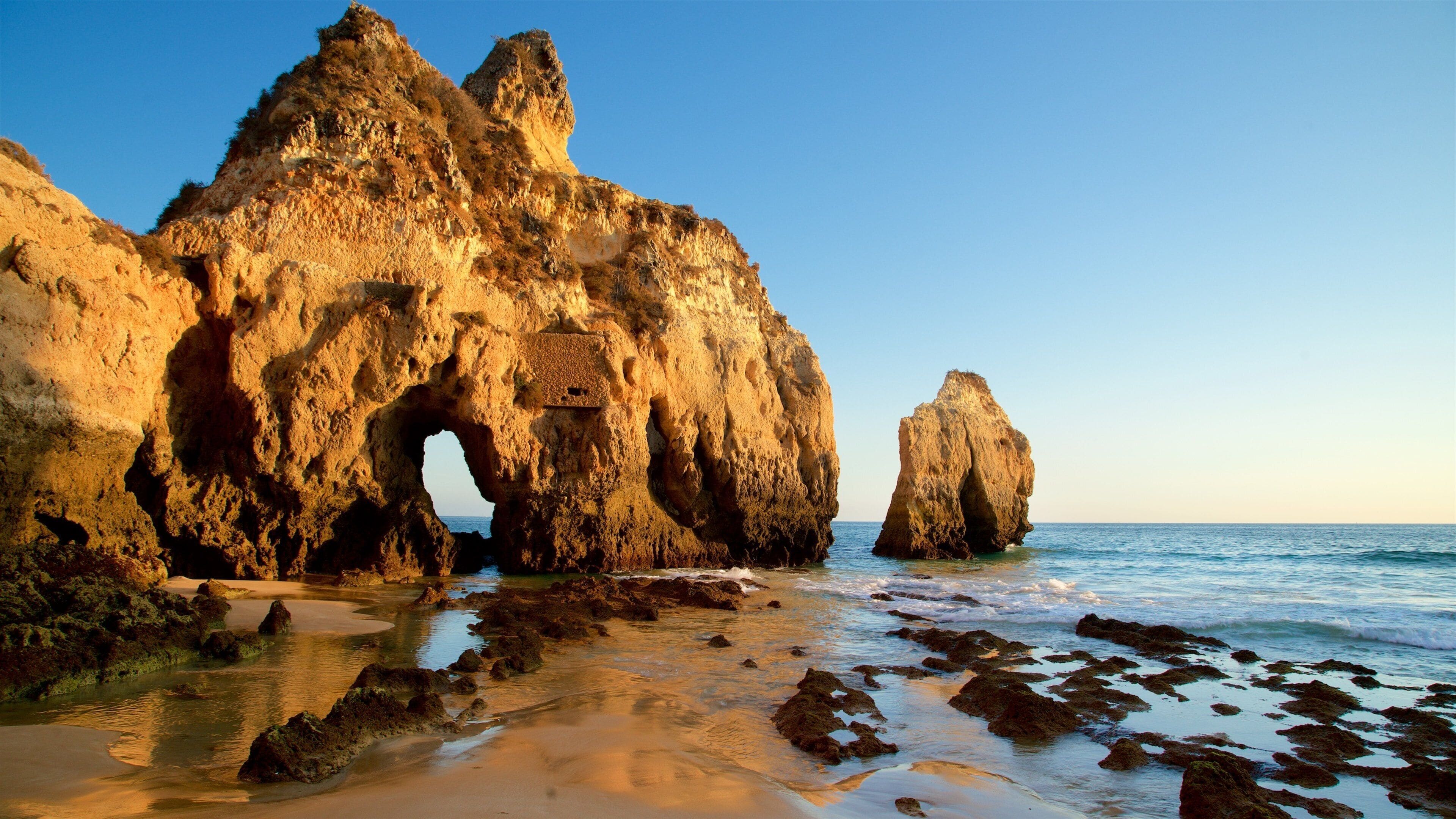Tres Irmaos Beach showing a sunset, general coastal views and rocky coastline