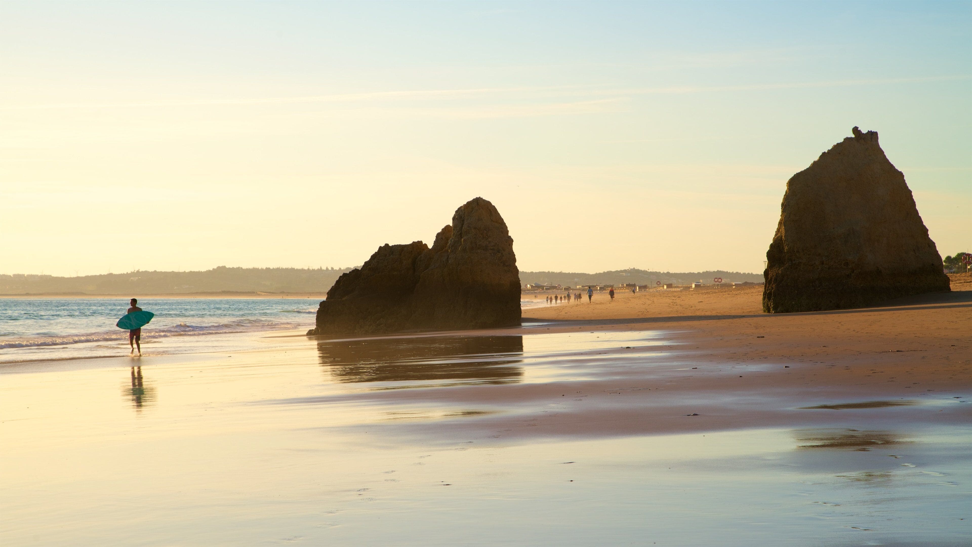 Tres Irmaos Beach which includes rocky coastline, general coastal views and a sunset