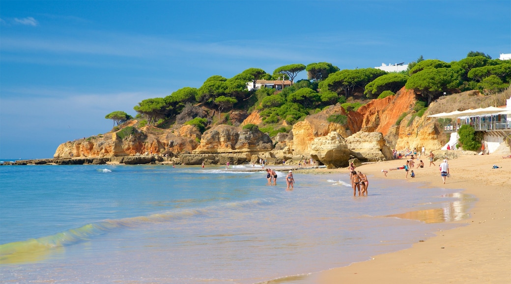 Playa Olhos D\'Agua ofreciendo litoral accidentado, una playa de arena y vistas de una costa