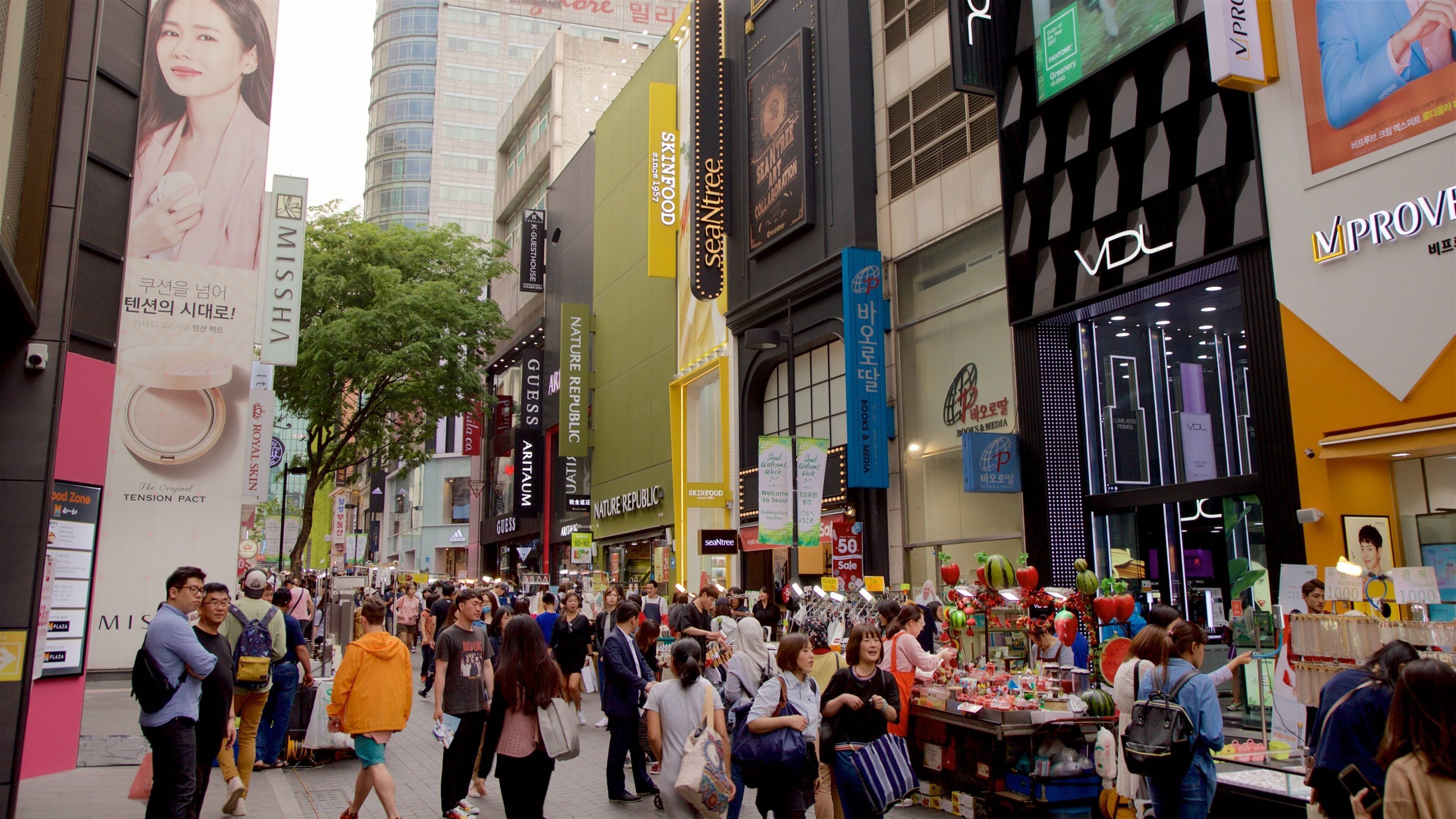 A busy urban street with various shops and advertisements.