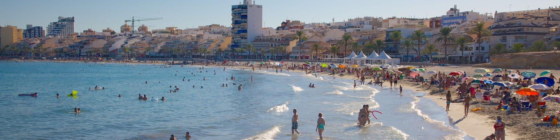 Campello Beach which includes a sandy beach, a coastal town and swimming