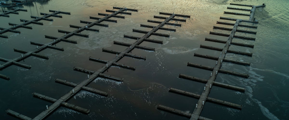 A tranquil scene at Lake Ontario as the sun rises behind the empty frozen docks