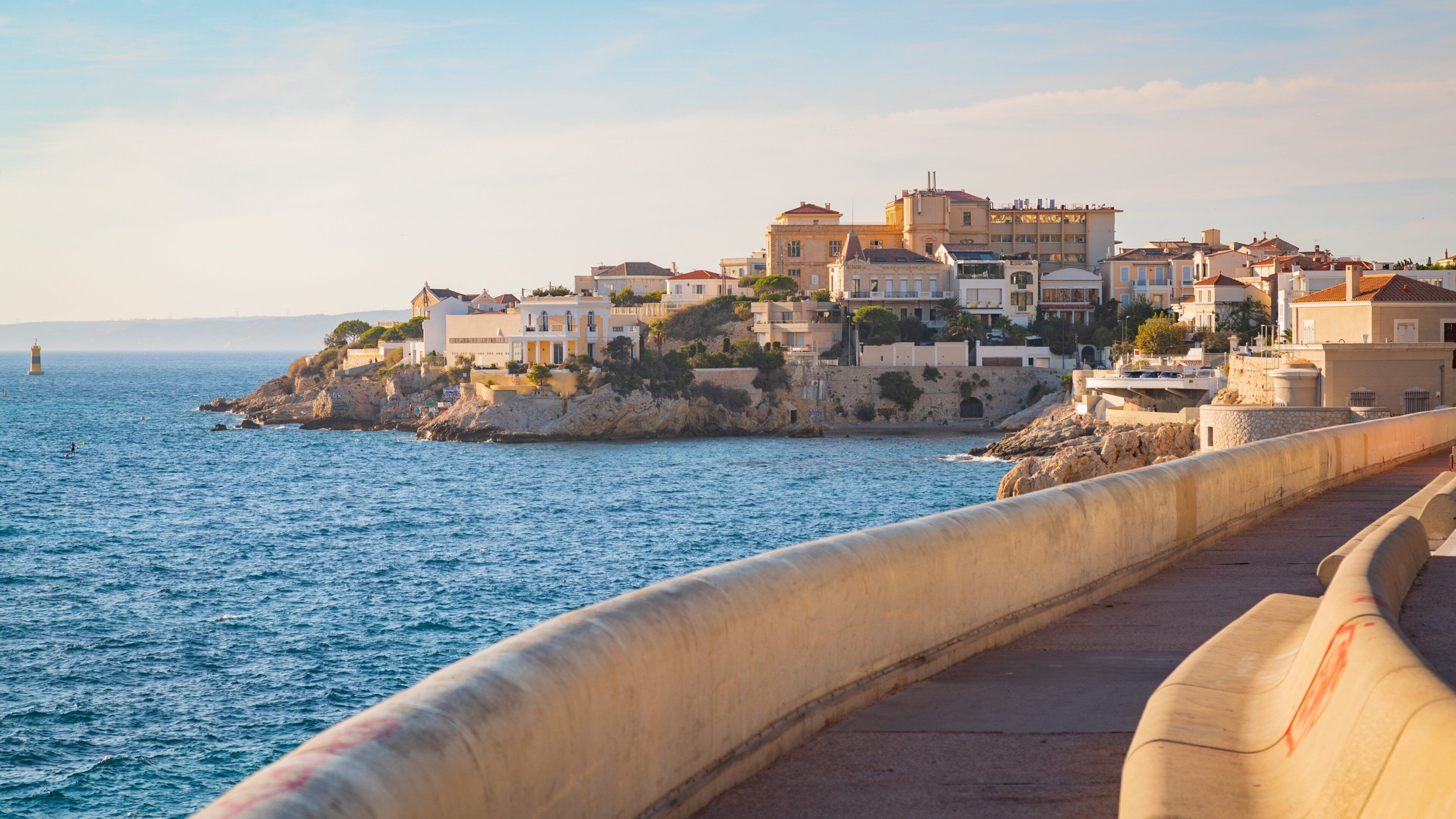 La Corniche featuring rocky coastline, a sunset and a coastal town