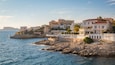 A coastal town with buildings along the cliffside overlooking the sea.
