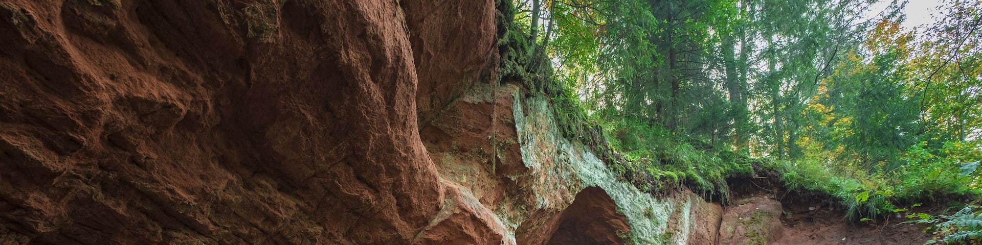 A rocky canyon with a narrow passageway and a dirt path leading through it.