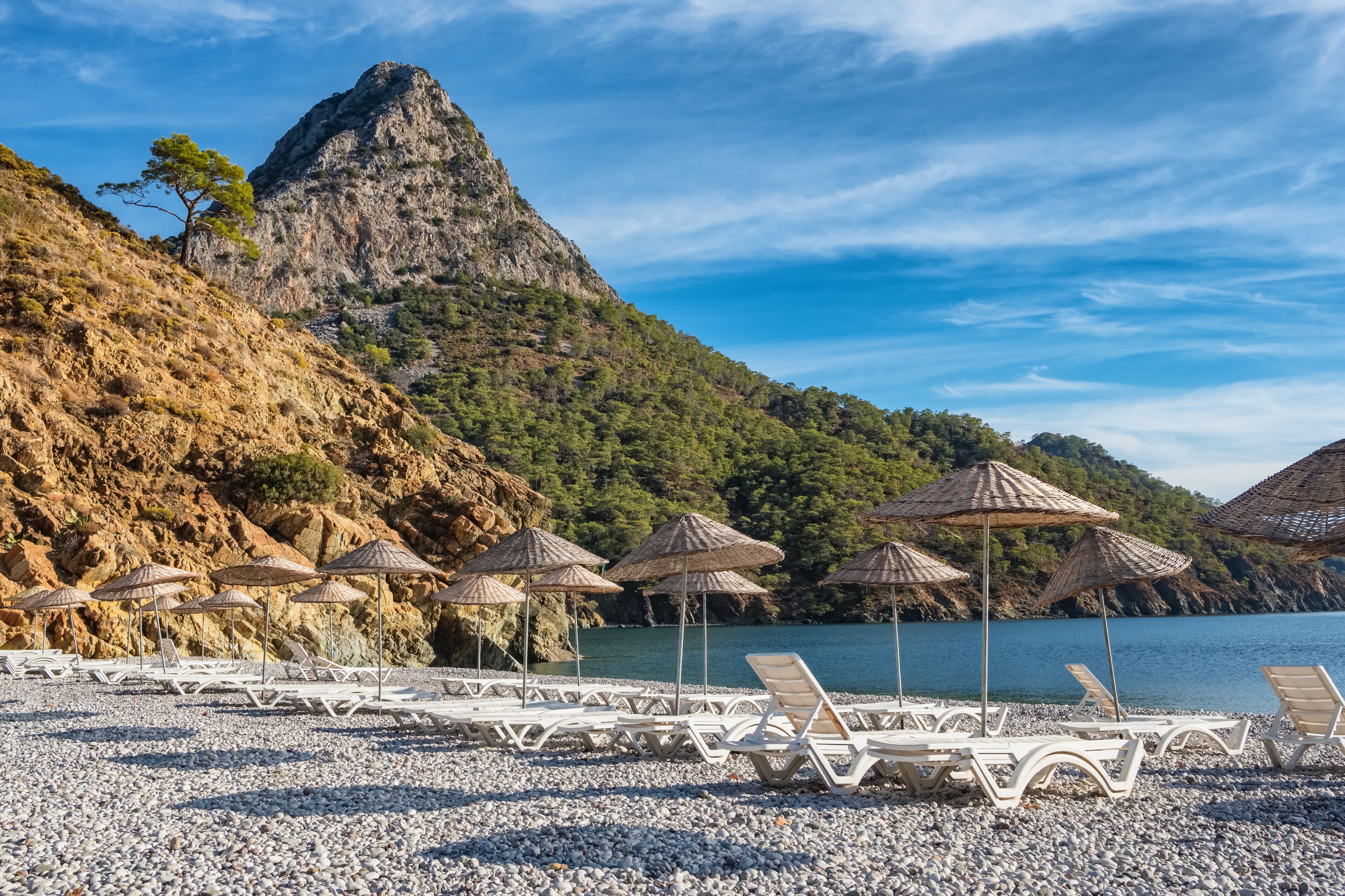 Beach umbrellas and sunbeds on the Adrasan beach in Turkey
