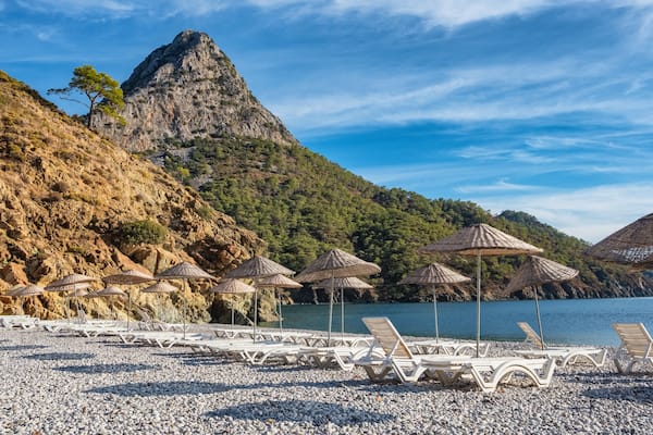 Beach umbrellas and sunbeds on the Adrasan beach in Turkey