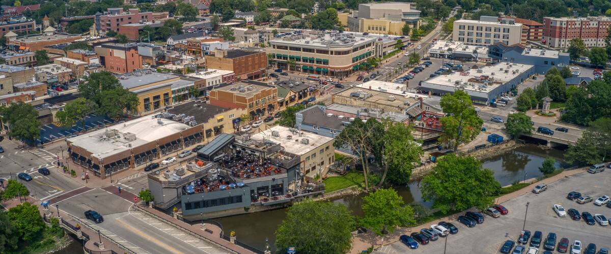 An aerial view of a city with a river, historic buildings, and a prominent church spire.