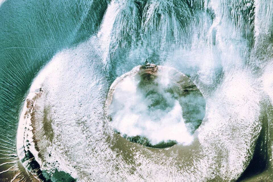 A large geyser with a circular pool and water spouting from the center.