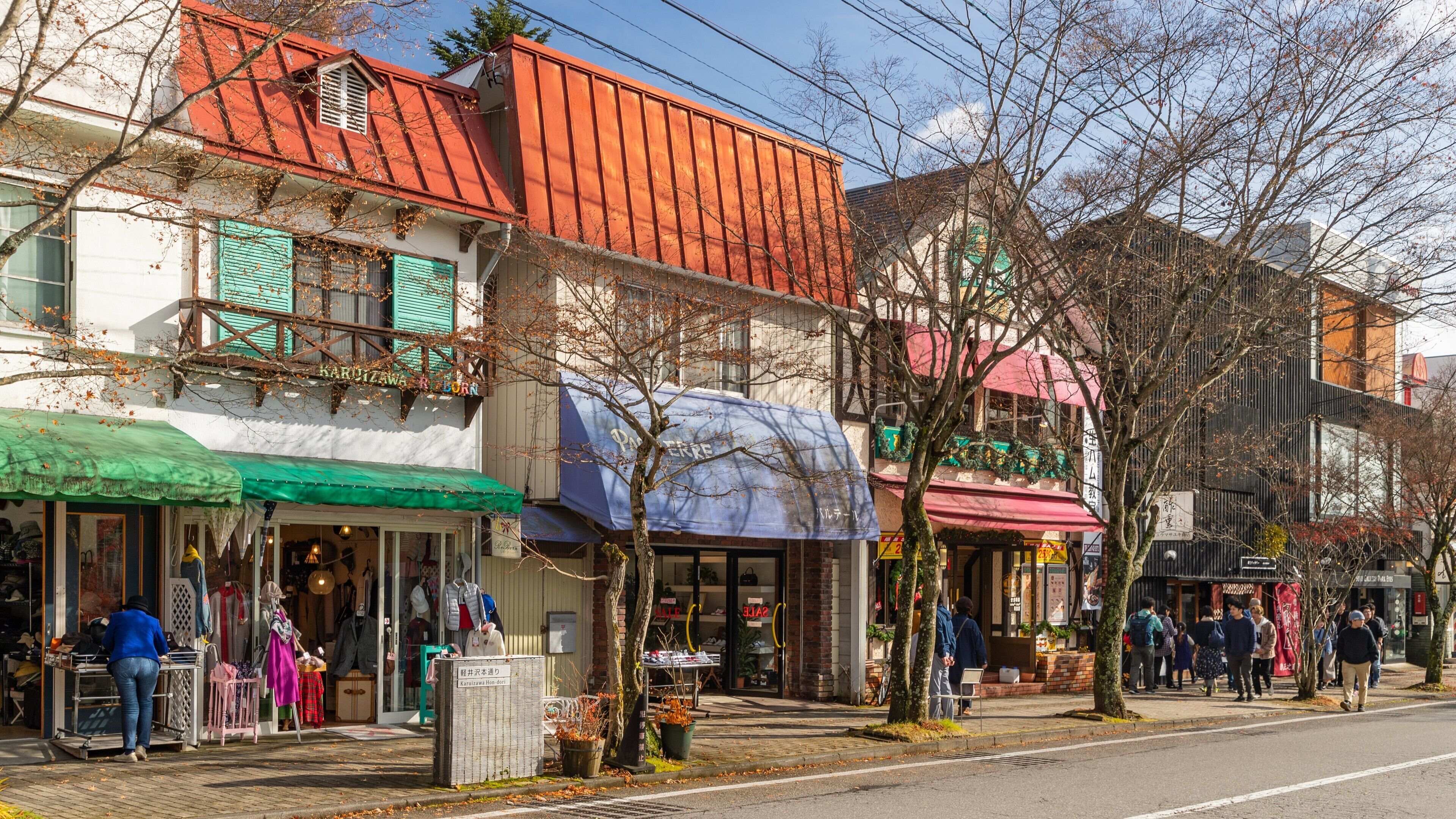 Rua repleta de edifícios coloridos, alguns com toldos verdes e outros com telhados vermelhos.