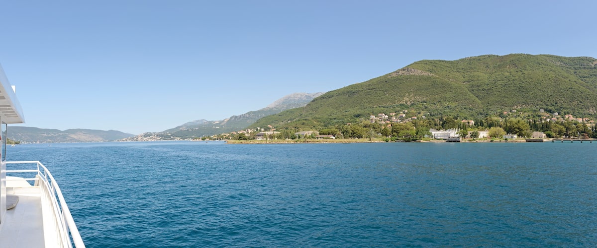A boat on a calm lake with a mountainous landscape in the background.
