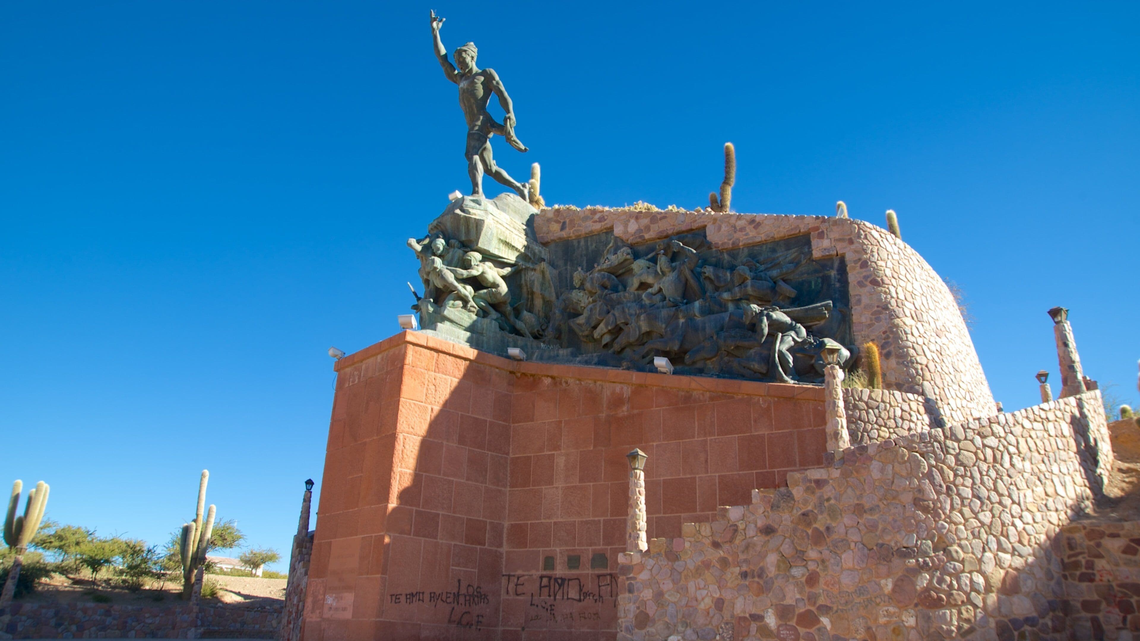 A historical monument with a statue of a man and a relief sculpture depicting a battle scene.