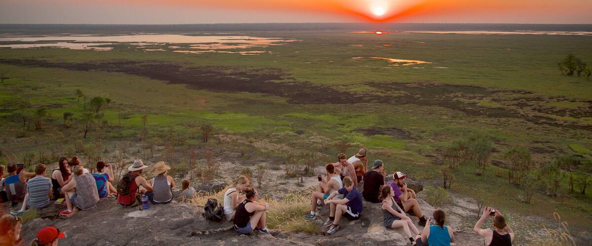 Ubirr welches beinhaltet Sonnenuntergang sowie große Menschengruppe