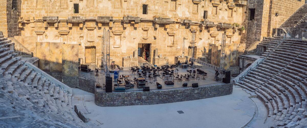An ancient amphitheater with stone steps and a central stage.