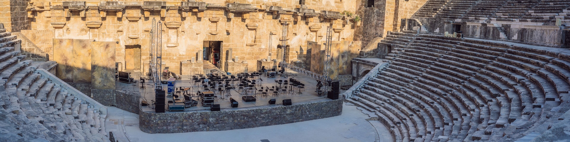 An ancient amphitheater with stone steps and a central stage.