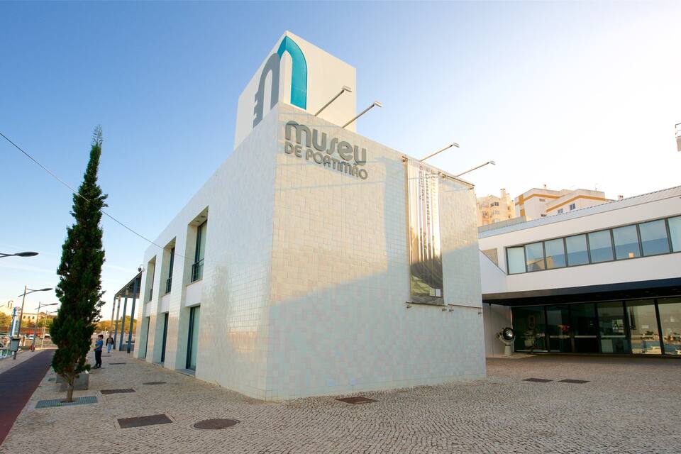 A modern building with a tiled facade and a blue archway, labeled 'Museu de Arte Moderno'.