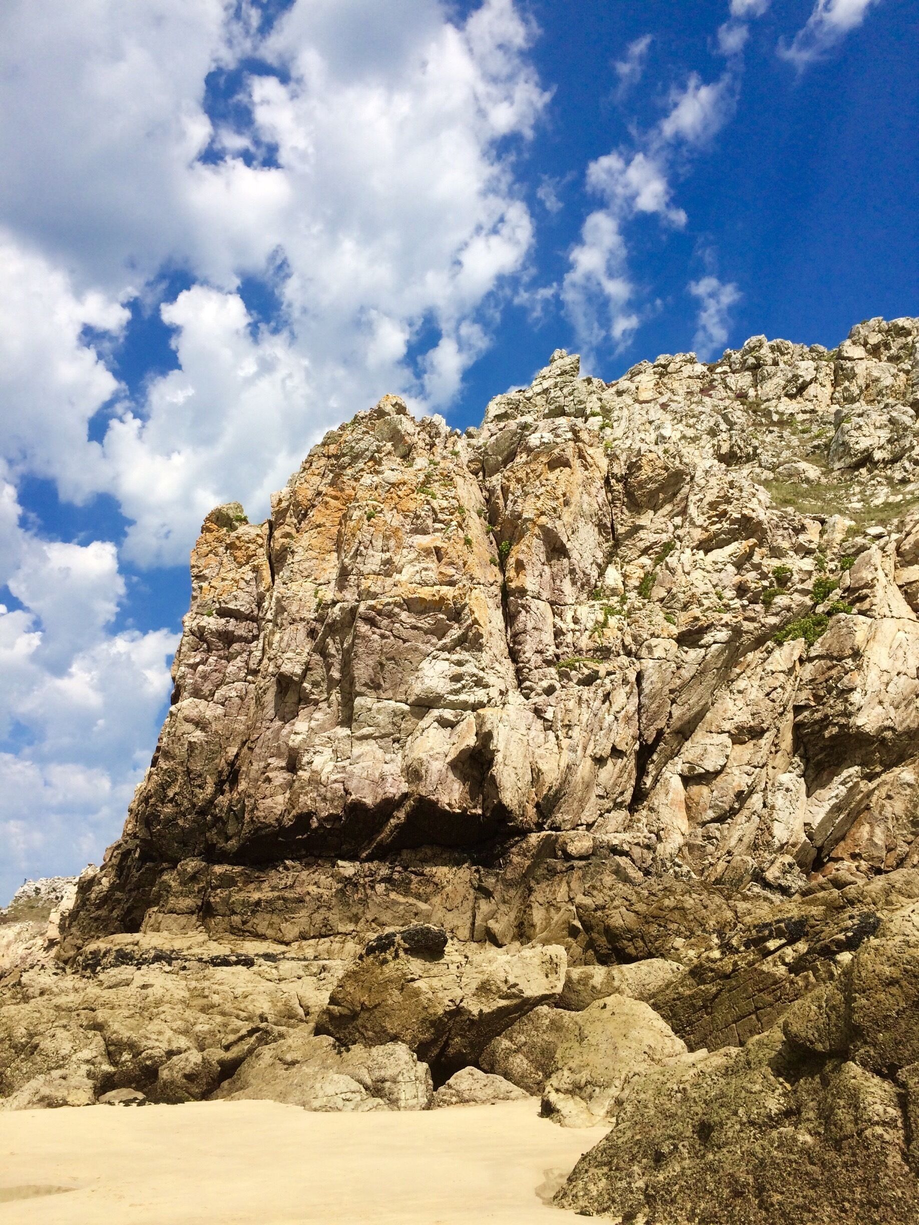 Rocky cliffs tower over the beach. 