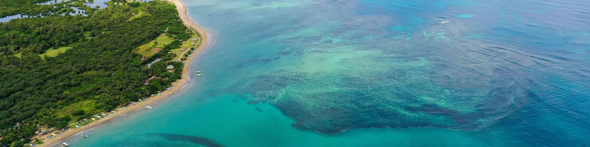 Malay archipelago with reefs and islands. Seascape with islands in the early morning, aerial drone. Beautiful landscape on the island of Luzon. Caramoan Islands, Philippines.