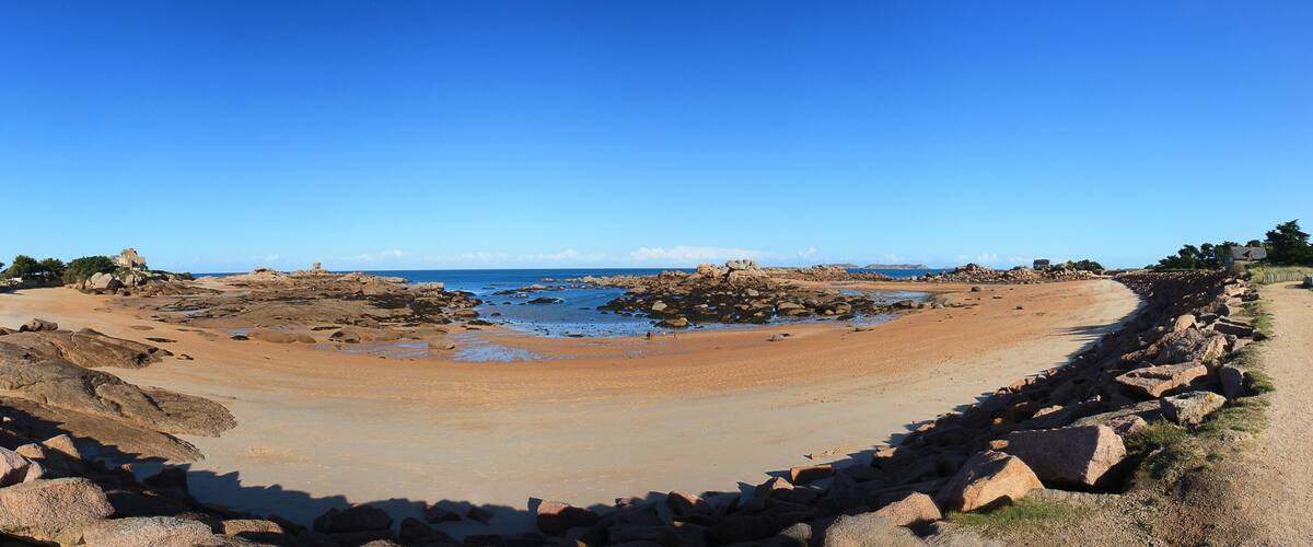 A rocky beach with a clear blue sky.