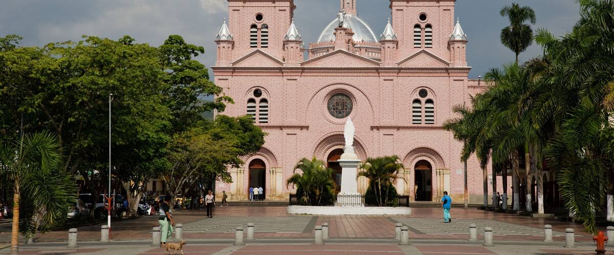 A large pink brick church with two towers and a central dome.