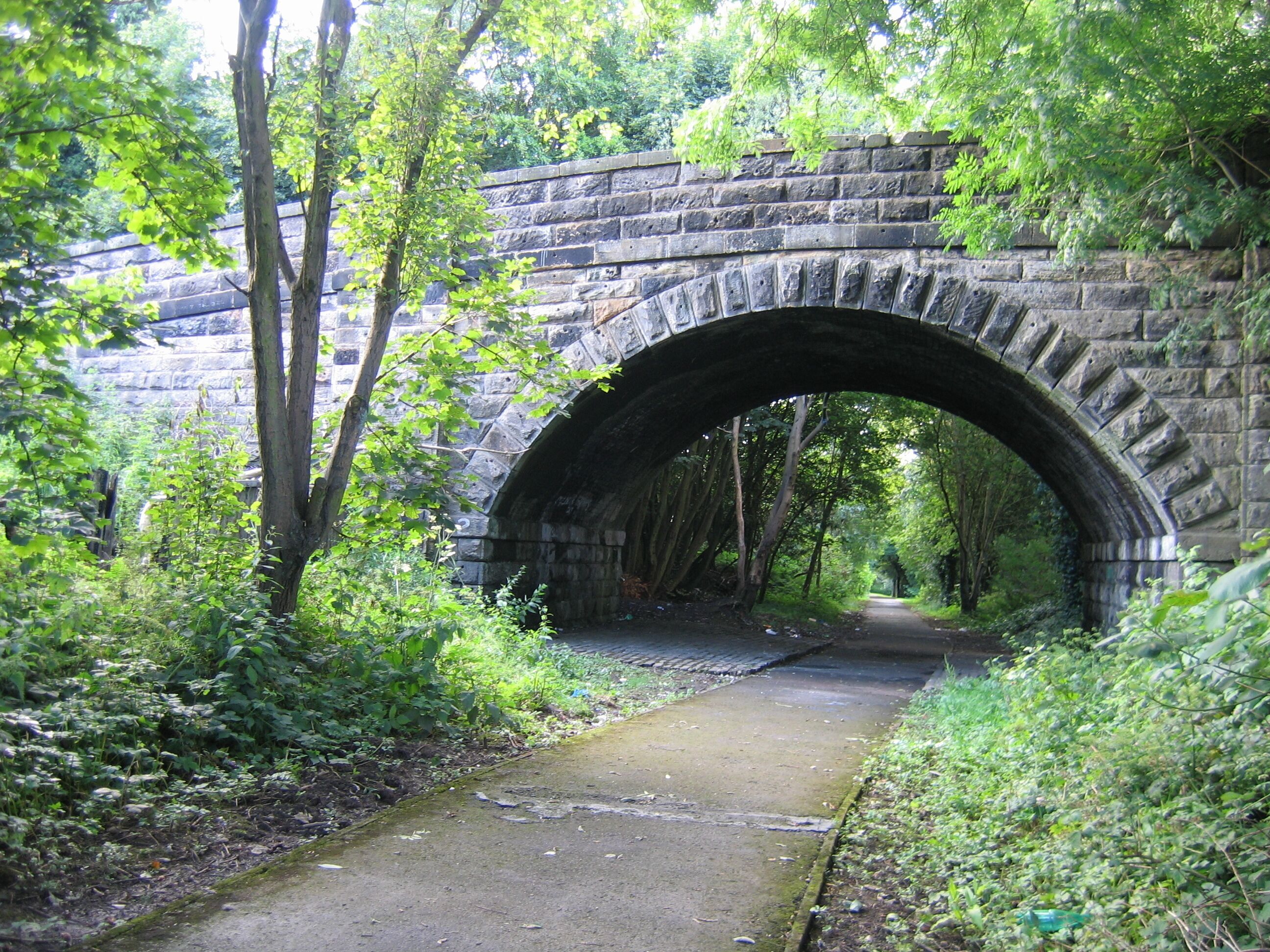 Railway bridge at Denny Denny was the terminus of passenger trains from Larbert until 1930 but beyond the station two goods-only branches extended to serve paper mills, gravel and sand pits, brick works and collieries. Both extensions have been converted into footpaths since complete closure in the "Beeching era". This is Herbertshire Street bridge No.2 on the branch that ran northwards past Dunipace to Ingliston goods depot. The bridge has been closed to vehicles and now carries only a footpath over "The Old Railway Path".