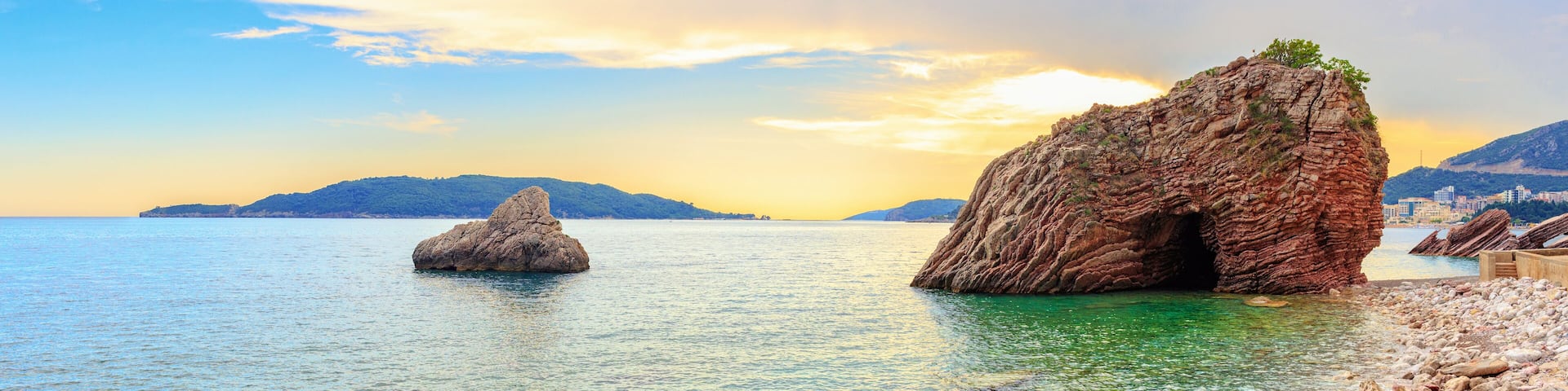 Sunset on the Adriatic sea near Budva city in Montenegro, gorgeous seascape with big rock in the beach